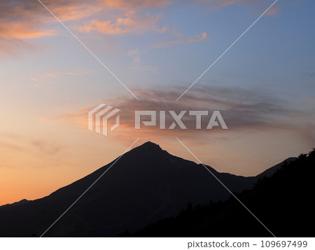 磐梯山的輪廓上被餘輝染成紅色的雲彩在藍天的襯托下顯得雄偉美麗。 109697499