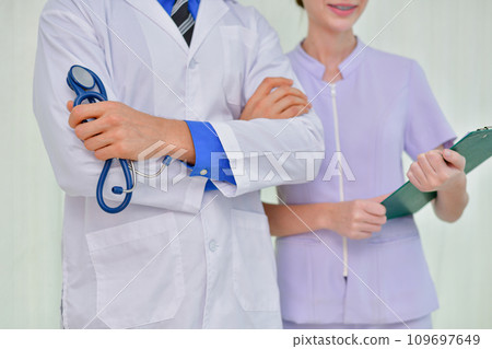 Doctor is crossing his arms in confidence in hospital. 109697649