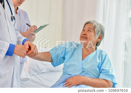 Doctor comforting patient in hospital room. He is holding the hand of a patient in the ward. Doctor comforting patient in hospital room. He is holding the hand of a patient in the ward. 109697650