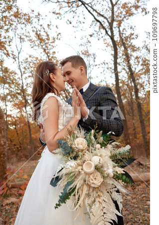 beautiful sensual bride in white wedding dress and groom standing outdoor on natural background beautiful sensual bride in white wedding dress and groom standing outdoor on natural background 109697798
