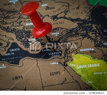 Close up red push pin pointing ISRAEL word on a world map 109698643
