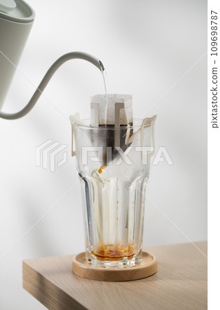 Brewing coffee through pre-made paper filters. Brewing coffee through pre-made paper filters. 109698787