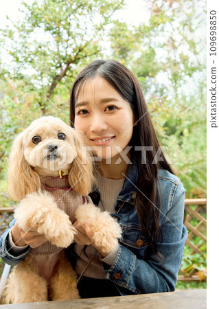 A woman interacting with her dog at a dog cafe 109698850