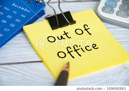 Out of office text on sticky notepad with December calendar and calculator background Out of office text on sticky notepad with December calendar and calculator background 109698863