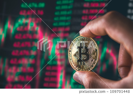 Bitcoin Blockchain Technology and Cryptocurrency. Hand holding bitcoin with graph background for Digital Finance and trading concept. 109701448