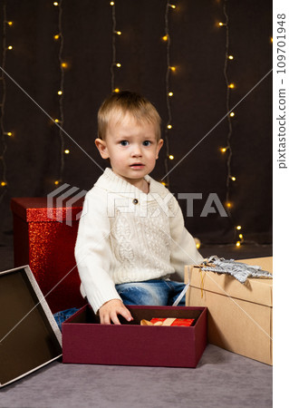Little two-year-old boy opens Christmas gifts at home 109701948
