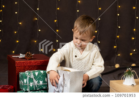 Little two-year-old boy opens Christmas gifts at home 109701953