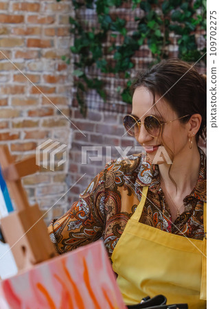 Woman with brush painting on canvas 109702275
