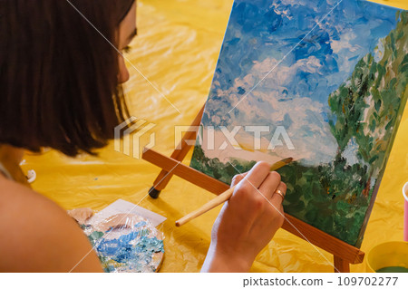 Woman with brush painting on canvas 109702277