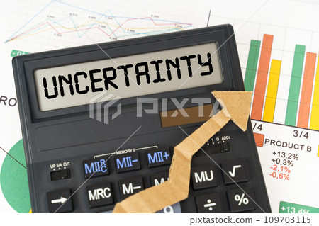 On the business charts there is a calculator on the screen with the inscription - Uncertainty On the business charts there is a calculator on the screen with the inscription - Uncertainty 109703115