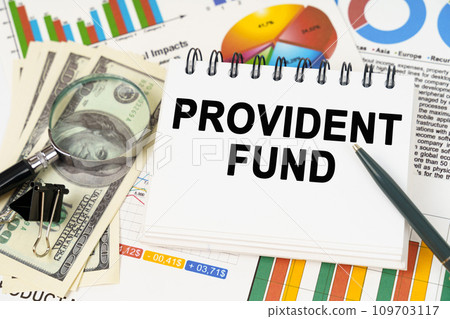 On the table are business charts, dollars and a notepad with the inscription - PROVIDENT FUND On the table are business charts, dollars and a notepad with the inscription - PROVIDENT FUND 109703117