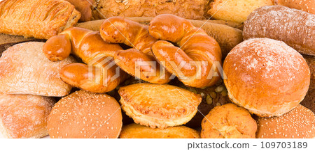 Croissants and sweet pastries background. Wide photo. Croissants and sweet pastries background. Wide photo. 109703189
