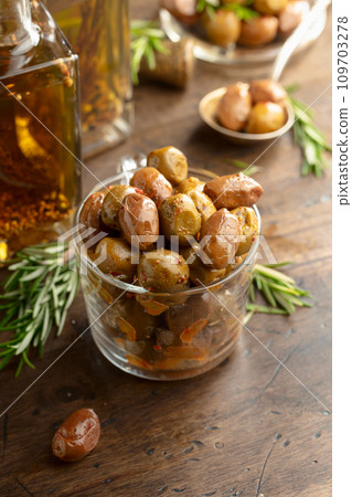 Spicy olives and bottles of olive oil on a wooden table. Spicy olives and bottles of olive oil on a wooden table. 109703278
