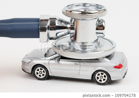A stethoscope lies on the roof of a toy car. Car diagnostics, repair and maintenance concept A stethoscope lies on the roof of a toy car. Car diagnostics, repair and maintenance concept 109704178