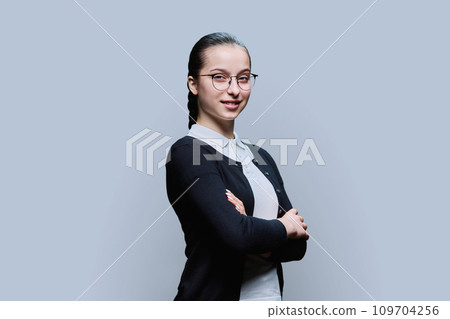 Portrait of confident smiling teenager girl on grey background Portrait of confident smiling teenager girl on grey background 109704256