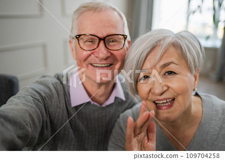 Happy senior woman man talk on video call with friends family. Mature old grandmother grandfather talking speaking with grown up children online. Older generation modern tech usage. Webcamera view Happy senior woman man talk on video call with friends family. Mature old grandmother grandfather talking speaking with grown up children online. Older generation modern tech usage. Webcamera view 109704258
