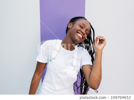 Young female with braids having fun. Girl in white overall with closed eyes. Young female with braids having fun. Girl in white overall with closed eyes. 109704652