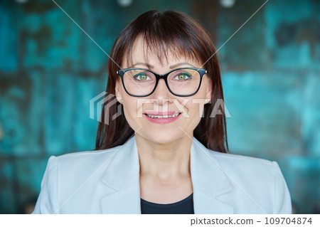 Headshot portrait of mature smiling business woman looking at camera 109704874