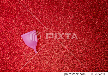 pink menstrual cup on shiny red background,top view. Zero waste concept. Eco-friendly menstrual products 109705291