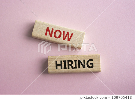 Now Hiring symbol. Concept word Now Hiring on wooden blocks. Beautiful pink background. Business and Now Hiring concept. Copy space 109705418
