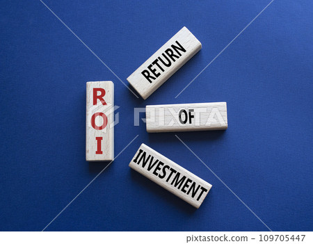 ROI - Return of Investment. Wooden cubes with words ROI. Beautiful deep blue background. Business and ROI concept. Copy space. 109705447