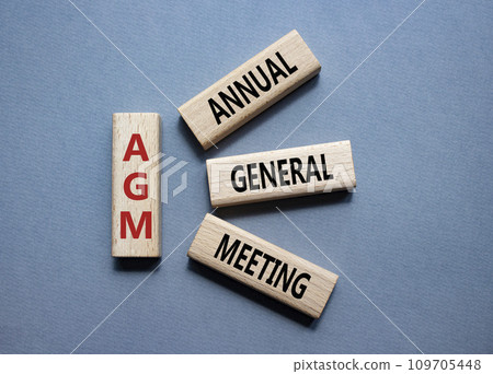 AGM - Annual general meeting symbol. Concept word AGM on wooden blocks. Beautiful grey background. Business and AGM concept. Copy space. 109705448