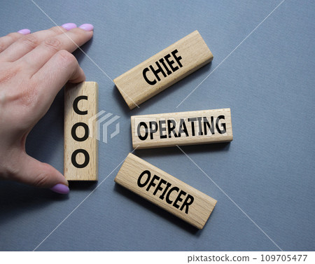 COO - Chief Operating Officer symbol. Concept word COO on wooden blocks. Businessman hand. Beautiful grey background. Business and COO concept. Copy space. 109705477
