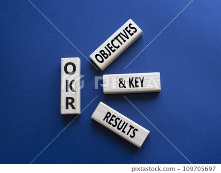 OKR objectives and key results symbol. Wooden blocks with words OKR objectives and key results. Beautiful deep blue background. Business and OKR concept. Copy space. 109705697