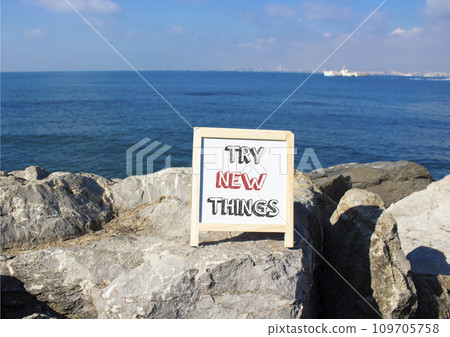 Try new Things symbol. Concept words Try new Things on white chalk blackboard blocks. Beautiful sea green background. Business and Try new Things concept. Copy space. 109705758