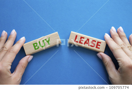 Buy or Lease symbol. Concept word Buy or Lease on wooden blocks. Businessman hand. Beautiful blue background. Business and Buy or Lease concept. Copy space 109705774