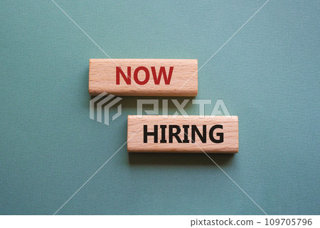 Now Hiring symbol. Concept word Now Hiring on wooden blocks. Beautiful grey green background. Business and Now Hiring concept. Copy space 109705796