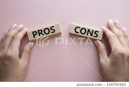 Pros vs Cons symbol. Concept word Pros vs Cons on wooden blocks. Businessman hand. Beautiful pink background. Business and Pros vs Cons concept. Copy space Pros vs Cons symbol. Concept word Pros vs Cons on wooden blocks. Businessman hand. Beautiful pink background. Business and Pros vs Cons concept. Copy space 109705983
