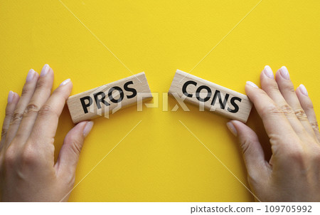 Pros vs Cons symbol. Concept word Pros vs Cons on wooden blocks. Businessman hand. Beautiful yellow background. Business and Pros vs Cons concept. Copy space 109705992