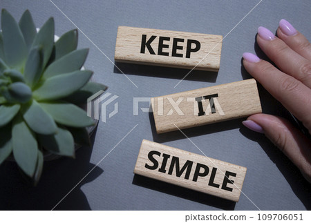 Keep it Simple symbol. Concept words Keep it Simple on wooden blocks. Businessman hand. Beautiful grey background with succulent plant. Business and Keep it Simple concept. Copy space. Keep it Simple symbol. Concept words Keep it Simple on wooden blocks. Businessman hand. Beautiful grey background with succulent plant. Business and Keep it Simple concept. Copy space. 109706051
