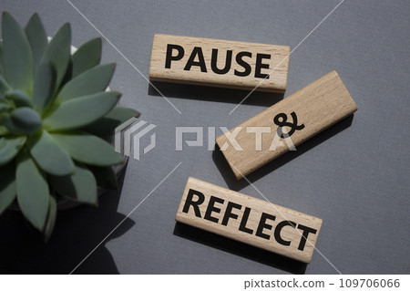 Pause and Reflect symbol. Concept words Pause and Reflect on wooden blocks. Beautiful grey background with succulent plant. Business and Pause and Reflect concept. Copy space. Pause and Reflect symbol. Concept words Pause and Reflect on wooden blocks. Beautiful grey background with succulent plant. Business and Pause and Reflect concept. Copy space. 109706066