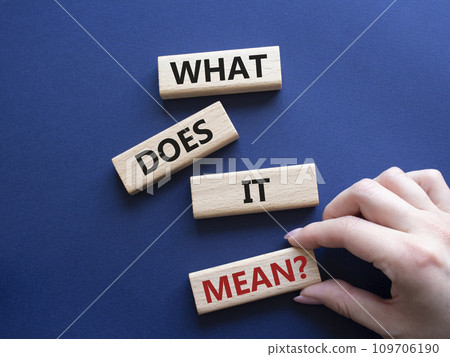 What does it mean symbol. Wooden blocks with words What does it mean. Beautiful deep blue background. Businessman hand. Business and What does it mean concept. Copy space. 109706190