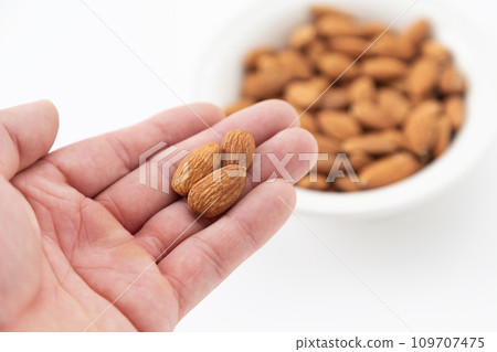 Man's hand holding an almond Man's hand holding an almond 109707475