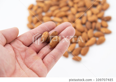 Man's hand holding an almond 109707485