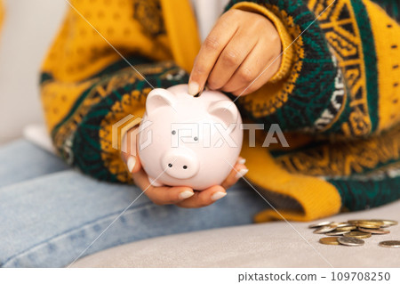 Saving money investment for future. Female woman hands holding pink piggy bank and putting money coin. Saving investment budget business wealth retirement financial money banking concept Saving money investment for future. Female woman hands holding pink piggy bank and putting money coin. Saving investment budget business wealth retirement financial money banking concept 109708250