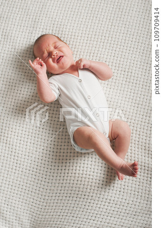 Crying baby 1 month old in hands of his father. Newborn baby colic close up. Crying baby 1 month old in hands of his father. Newborn baby colic close up. 109709414