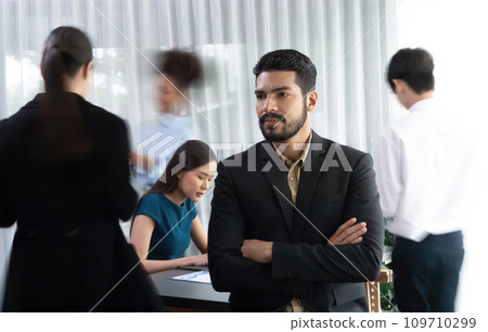 Businessman portrait poses confidently in busy meeting room. Concord Businessman portrait poses confidently in busy meeting room. Concord 109710299