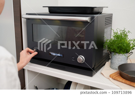 操作微波爐的女性烹飪手 109713896