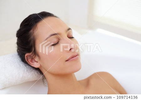 Relax, bath and face of woman in bathtub for wellness, stress relief or skin detox with comfort at home. Self care, peace or person bathing in tub for cleaning, pamper or diy spa bathroom treatment 109714136