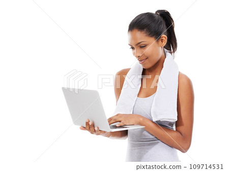 Fitness, internet and woman with a laptop, typing and smile isolated on a white studio background. Person, girl and model with a computer, connection and online with information, wellness and tech 109714531