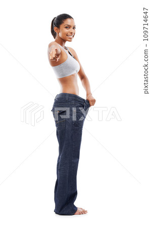 Happy woman, portrait and pointing to lose weight in jeans or decision against a white studio background. Slim female person or model smile for pick or choose in health and wellness on mockup space 109714647