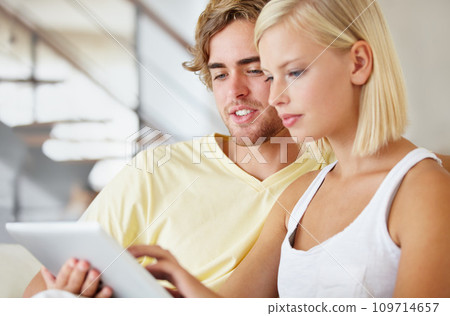 Relax, tablet and young couple on sofa browsing on social media or internet at apartment. Smile, digital technology and man and woman from Australia scroll on website together in living room at home. 109714657