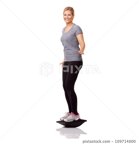 Exercise, studio portrait and woman with board balance, smile and healthy body workout at gym. Fitness, stability and happy girl with wellness, pilates training and tools isolated on white background Exercise, studio portrait and woman with board balance, smile and healthy body workout at gym. Fitness, stability and happy girl with wellness, pilates training and tools isolated on white background 109714800