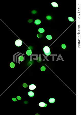 Green light, bokeh and shine on black background isolated on a mockup space. Blur, dark backdrop and defocused glow, sparkle or glitter at night for Christmas, holiday or party with magic color dots 109715398