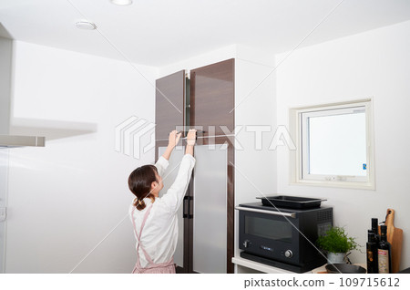 Woman opening cupboard, housewife, housework, cooking, cleaning up 109715612