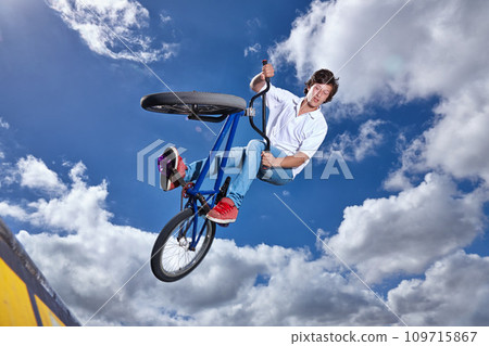 Trick, jump and man with bike in sky at park, event or competition for sport with risk, energy or freedom. Mockup, space or person in air with fearless stunt on bicycle for fun adventure in summer 109715867